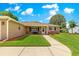 Charming home featuring a well-kept lawn, complemented by a clear blue sky with scattered clouds on a sunny day at 9790 Se 175Th St, Summerfield, FL 34491