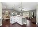 Spacious kitchen island features white cabinets, pendant lighting, and beautiful marble countertops at 9790 Se 175Th St, Summerfield, FL 34491