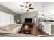 Inviting living room with hardwood floors, neutral walls, a ceiling fan, and an open layout leading to the kitchen at 9790 Se 175Th St, Summerfield, FL 34491