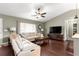 Comfortable living room featuring hardwood floors, neutral paint, a ceiling fan, and a large window for natural light at 9790 Se 175Th St, Summerfield, FL 34491