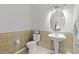 Half bath featuring sink with unique base and mirror, toilet, and tiled walls at 1055 Avenida Sonoma, Lady Lake, FL 32159