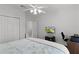 Light bedroom featuring white walls, ceiling fan, and closet with an entertainment center at 1055 Avenida Sonoma, Lady Lake, FL 32159