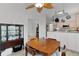 Dining area adjacent to kitchen features wood table, chairs, wood floors, ceiling fan and a china cabinet at 1055 Avenida Sonoma, Lady Lake, FL 32159