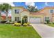 Charming two-story home with a well-manicured lawn, lush landscaping, and a two-car garage at 1055 Avenida Sonoma, Lady Lake, FL 32159