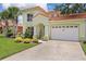 Charming two-story home with a well-manicured lawn, lush landscaping, and a two-car garage at 1055 Avenida Sonoma, Lady Lake, FL 32159