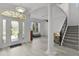 Elegant foyer showcasing wood-look floors, a staircase, and an inviting entrance into the living room at 1055 Avenida Sonoma, Lady Lake, FL 32159