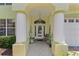 Welcoming home entrance featuring decorative columns, textured stone floor, and a charming glass front door at 1055 Avenida Sonoma, Lady Lake, FL 32159