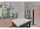 Bright kitchen with light wood cabinets, gray countertop island and stainless steel appliances at 1055 Avenida Sonoma, Lady Lake, FL 32159