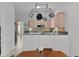 Bright kitchen with light wood cabinets, gray countertops and stainless steel microwave and pot rack at 1055 Avenida Sonoma, Lady Lake, FL 32159