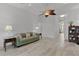 Spacious living room with wood-look flooring, a ceiling fan, and open access to other areas of the home at 1055 Avenida Sonoma, Lady Lake, FL 32159