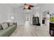 Open concept living room with wood-look flooring, ceiling fan, and access to other areas of the home at 1055 Avenida Sonoma, Lady Lake, FL 32159