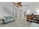 Open-concept living room featuring wood-look flooring, a ceiling fan, and access to the staircase at 1055 Avenida Sonoma, Lady Lake, FL 32159