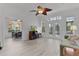 Bright living room with wood-look flooring, ceiling fan, and double doors to the outdoor living space at 1055 Avenida Sonoma, Lady Lake, FL 32159
