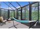 Relaxing sunroom with hammock, tile floors and screened windows overlooking lush greenery at 1055 Avenida Sonoma, Lady Lake, FL 32159