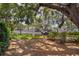View of parking lot and buildings beyond trees and a fence at 1055 Avenida Sonoma, Lady Lake, FL 32159