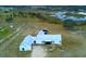 Modern farmhouse with metal roof from an aerial perspective nestled in a lush landscape at 10711 County Road 561, Clermont, FL 34711