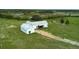 Aerial view of the home showing the metal roof, green pasture and long driveway at 10711 County Road 561, Clermont, FL 34711