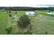 Expansive aerial shot of the modern home and the property featuring green land and mature trees at 10711 County Road 561, Clermont, FL 34711