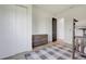 Bedroom with light wood floors and grey and white rug leading to white closet doors at 10711 County Road 561, Clermont, FL 34711