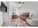 Bright Bedroom features a wooden crib, dresser, and cozy chair on a floral rug at 10711 County Road 561, Clermont, FL 34711
