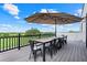 Outdoor patio with a long table, seating, black railings, and views of the surrounding natural landscape at 10711 County Road 561, Clermont, FL 34711