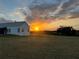 Beautiful home exterior at sunset in the countryside with rolling clouds at 10711 County Road 561, Clermont, FL 34711