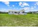Modern farmhouse with a metal roof, black framed windows and doors and spacious backyard with an expansive green lawn at 10711 County Road 561, Clermont, FL 34711