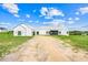 New white farmhouse design with metal roof in a sunny, open landscape at 10711 County Road 561, Clermont, FL 34711