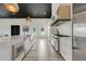 Modern kitchen boasts white cabinets, stainless steel appliances, and a spacious island with seating at 10711 County Road 561, Clermont, FL 34711