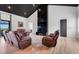 Large living room with a black fireplace feature wall, recliners, and wood-look flooring at 10711 County Road 561, Clermont, FL 34711