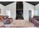 Bright living room with fireplace, leather sofas and chairs, and wood-look floors at 10711 County Road 561, Clermont, FL 34711