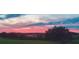 Beautiful sunset view over the tree line and green pasture of the property at 10711 County Road 561, Clermont, FL 34711