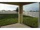 View of the backyard from the covered patio, featuring a large grassy area and vinyl fence at 1138 Calico Pointe Cir, Groveland, FL 34736