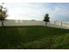 A spacious backyard, enclosed by a white vinyl fence, with a few trees in the yard at 1138 Calico Pointe Cir, Groveland, FL 34736