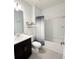 Well-lit bathroom with a dark vanity, shower-tub combination, and sleek fixtures at 1138 Calico Pointe Cir, Groveland, FL 34736