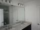 Bathroom featuring a double vanity, large mirror, and lots of counter space at 1138 Calico Pointe Cir, Groveland, FL 34736
