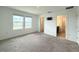Sunlit bedroom features neutral carpet, two windows, bathroom and TV connection offering bright modern comfort at 1138 Calico Pointe Cir, Groveland, FL 34736