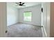 Bedroom with neutral carpet, a bright window offering a view, and light-colored walls at 1138 Calico Pointe Cir, Groveland, FL 34736