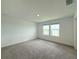 The room features neutral carpet, and two windows, offering ample natural light and a comfortable living space at 1138 Calico Pointe Cir, Groveland, FL 34736