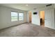 Sunlit bedroom with neutral carpet, two windows, bathroom and TV connections offering bright modern comfort at 1138 Calico Pointe Cir, Groveland, FL 34736