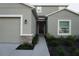 Home featuring an attached two-car garage, stone details, and simple landscaping at 1138 Calico Pointe Cir, Groveland, FL 34736