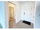 Bright entryway featuring white doors, ceramic tile floors, a black floor mat, and open access to other rooms at 1138 Calico Pointe Cir, Groveland, FL 34736