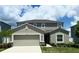 Two-story home featuring neutral paint, two car garage, manicured landscaping, and a concrete driveway at 1138 Calico Pointe Cir, Groveland, FL 34736