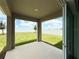 A covered patio overlooks the green, well-maintained backyard at 1138 Calico Pointe Cir, Groveland, FL 34736