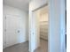 Hallway featuring door to walk-in closet with multiple shelves for optimal storage space at 1138 Calico Pointe Cir, Groveland, FL 34736