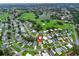 Aerial view of community, highlighting golf course, lake, and residential street at 1142 W Boone Ct, Lady Lake, FL 32159