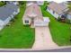 Aerial view of home featuring driveway, neutral roof, landscaping, and lawn at 1142 W Boone Ct, Lady Lake, FL 32159