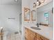 Bathroom featuring wood cabinets, white marble countertops, and a walk-in shower at 1142 W Boone Ct, Lady Lake, FL 32159