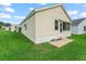 Exterior of home featuring neutral siding, concrete foundation, and well-maintained lawn at 1142 W Boone Ct, Lady Lake, FL 32159