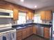 Well-lit kitchen featuring wood cabinets, stainless steel appliances, and dark countertops at 1202 Deidrich Ct, Eustis, FL 32726